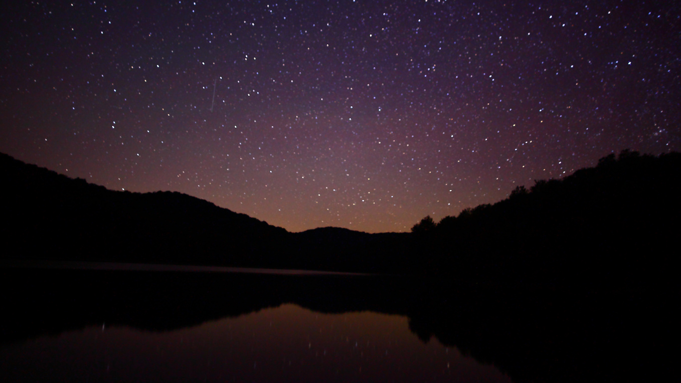 Silhouette of Mountain Near Body of Water During Night Time. Wallpaper in 1366x768 Resolution