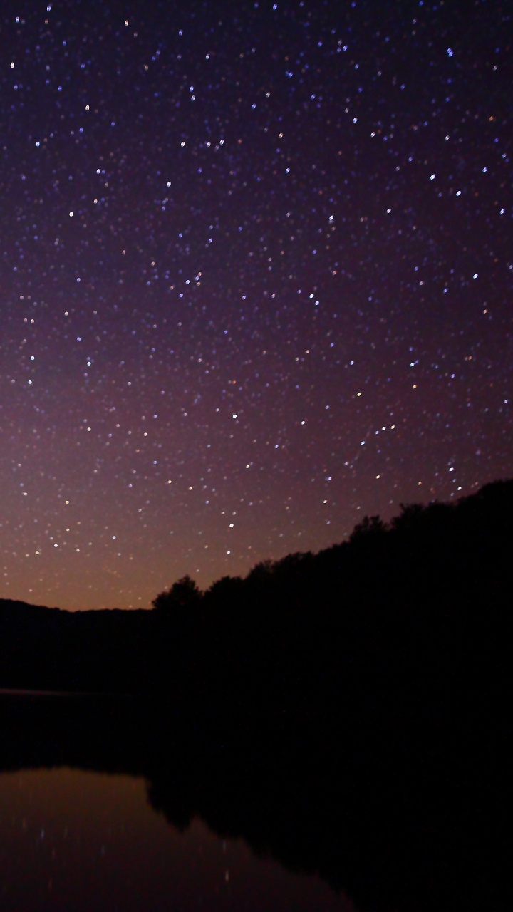 Silhouette of Mountain Near Body of Water During Night Time. Wallpaper in 720x1280 Resolution