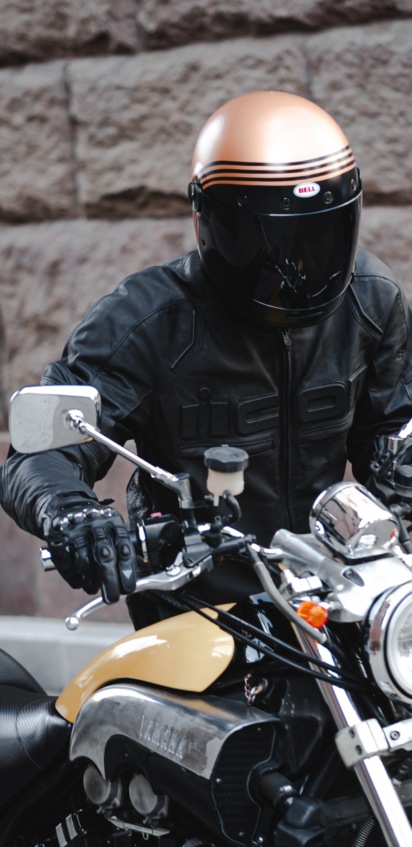 Mann in Schwarzer Lederjacke Mit Schwarzem Helm Auf Gelbem Motorrad. Wallpaper in 1440x2960 Resolution