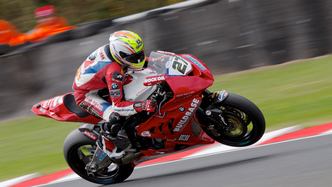 Man in Red and Black Motorcycle Suit Riding on Red Sports Bike. Wallpaper in 1366x768 Resolution