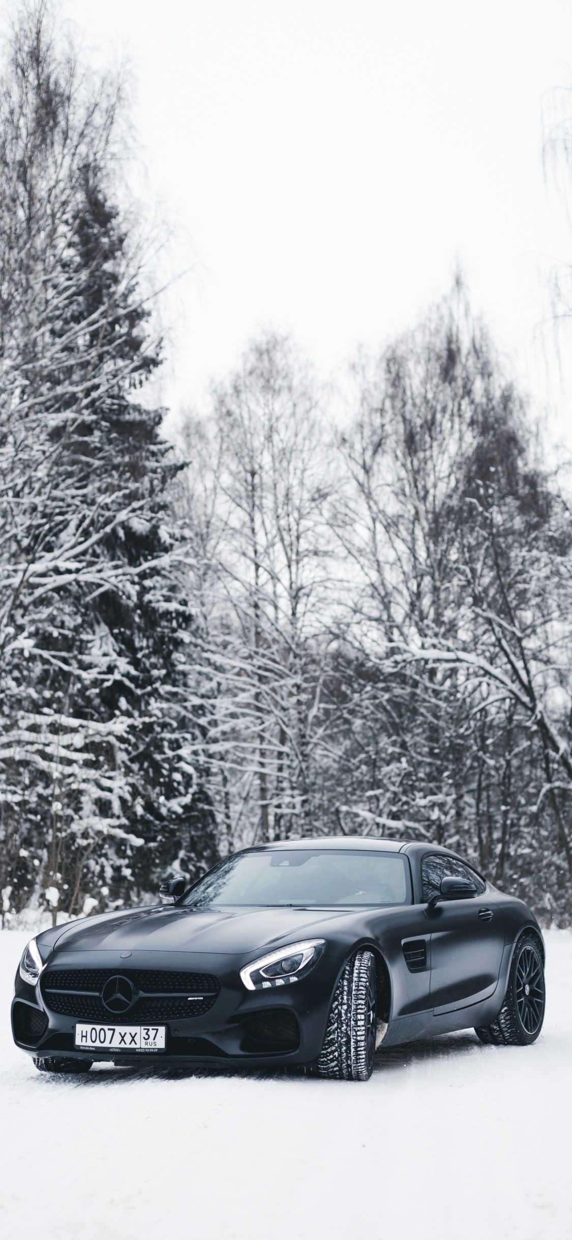 Schwarzes Bmw Coupe Auf Schneebedeckter Straße Tagsüber. Wallpaper in 1125x2436 Resolution
