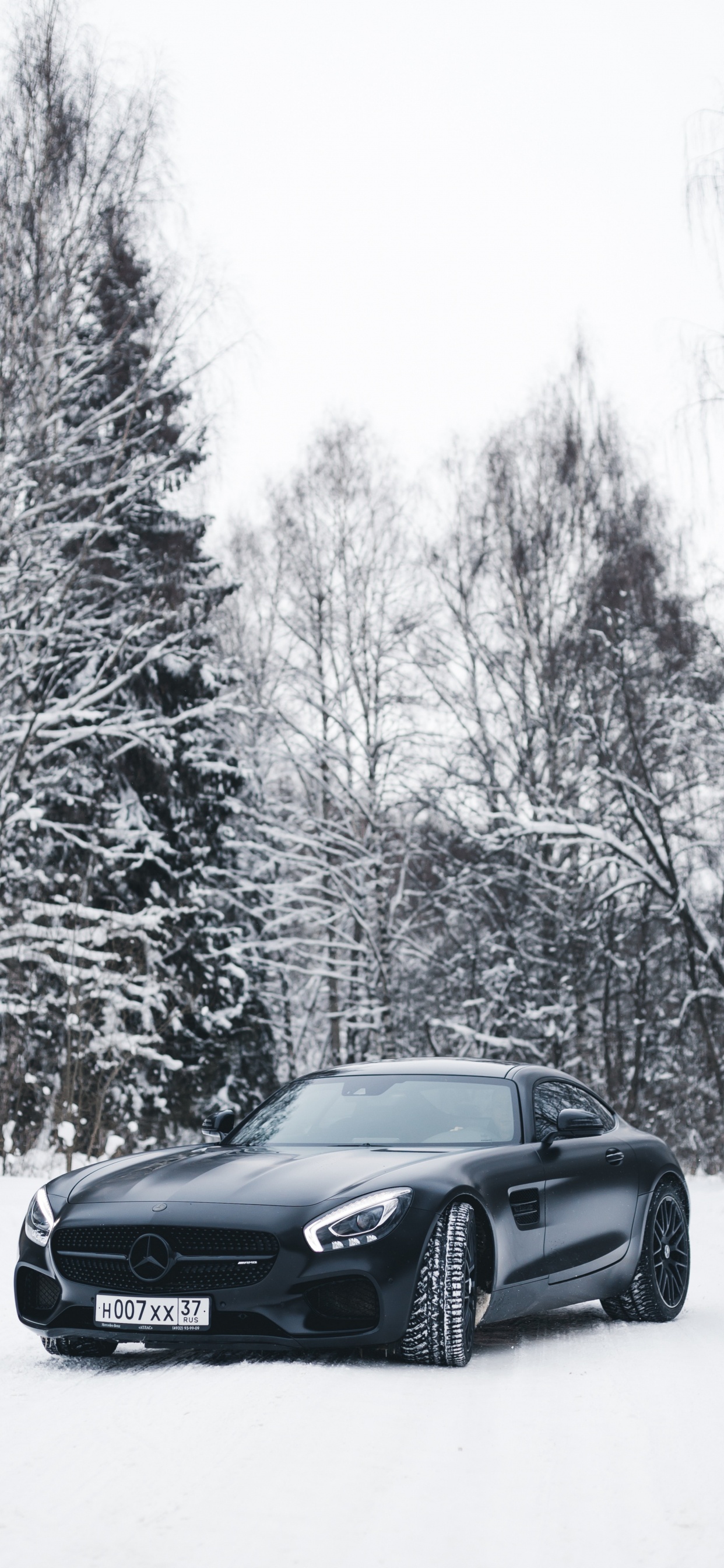 BMW Coupe Negro en Carreteras Cubiertas de Nieve Durante el Día. Wallpaper in 1242x2688 Resolution
