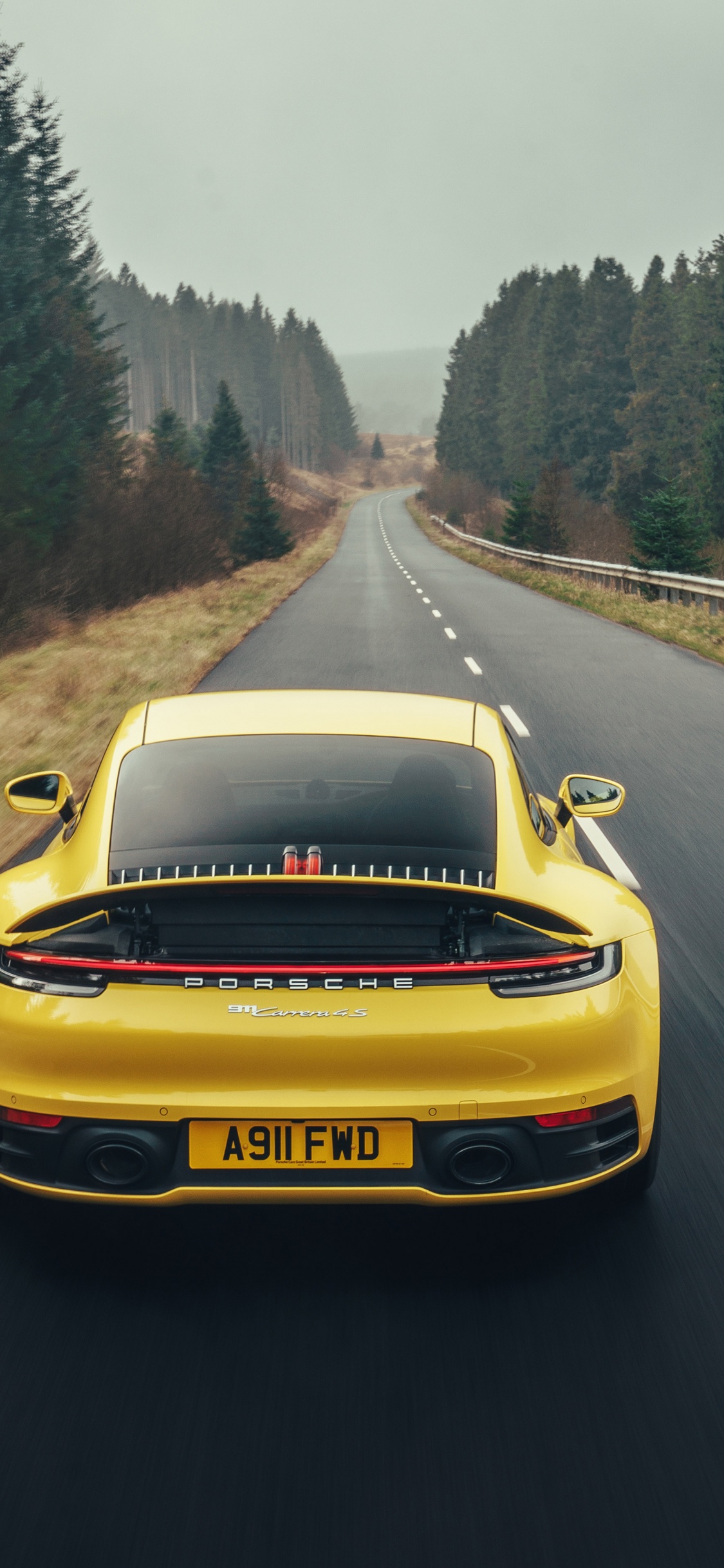 Porsche 911 Amarillo en la Carretera Durante el Día. Wallpaper in 1125x2436 Resolution