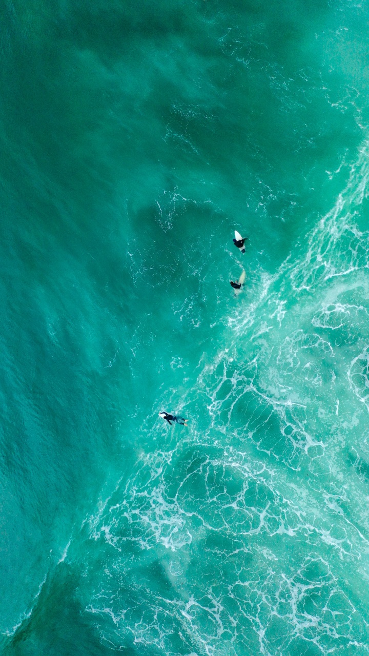 Personnes Surfant Sur la Mer Verte Pendant la Journée. Wallpaper in 720x1280 Resolution