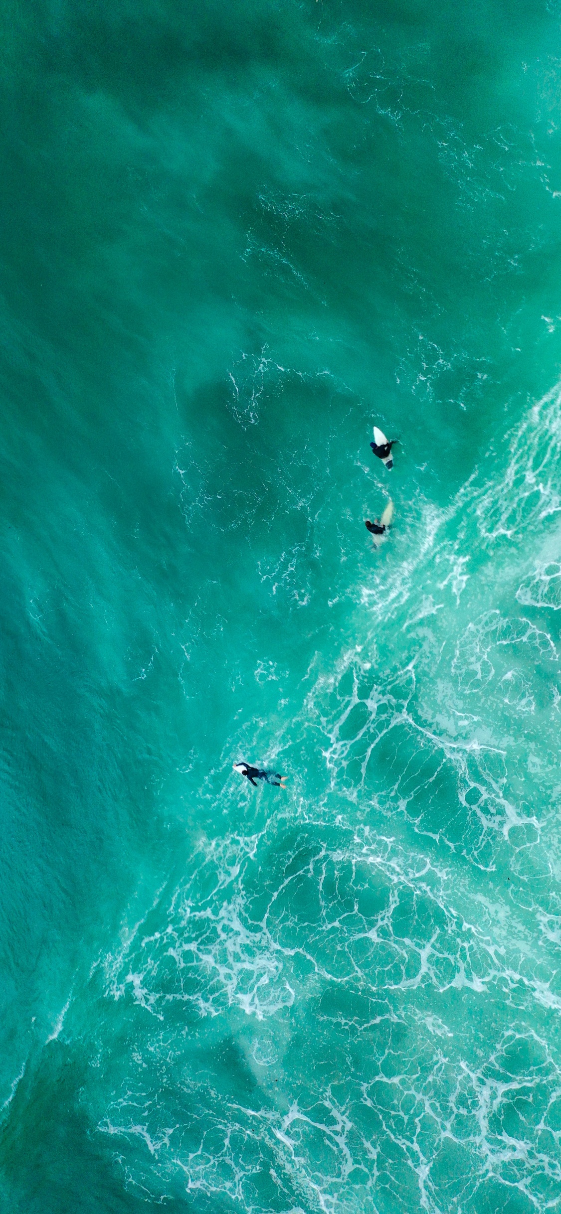 People Surfing on Green Sea During Daytime. Wallpaper in 1125x2436 Resolution