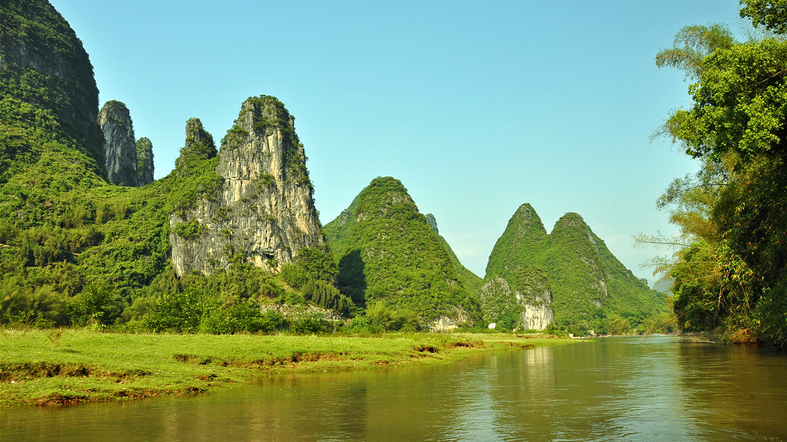 Green and Brown Mountain Beside Body of Water During Daytime. Wallpaper in 2560x1440 Resolution
