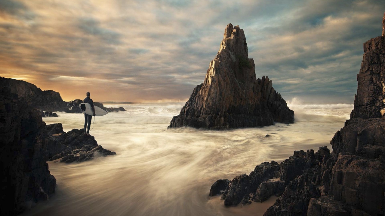 Homme Debout Sur Une Formation Rocheuse Près de L'eau de Mer Pendant la Journée. Wallpaper in 1280x720 Resolution