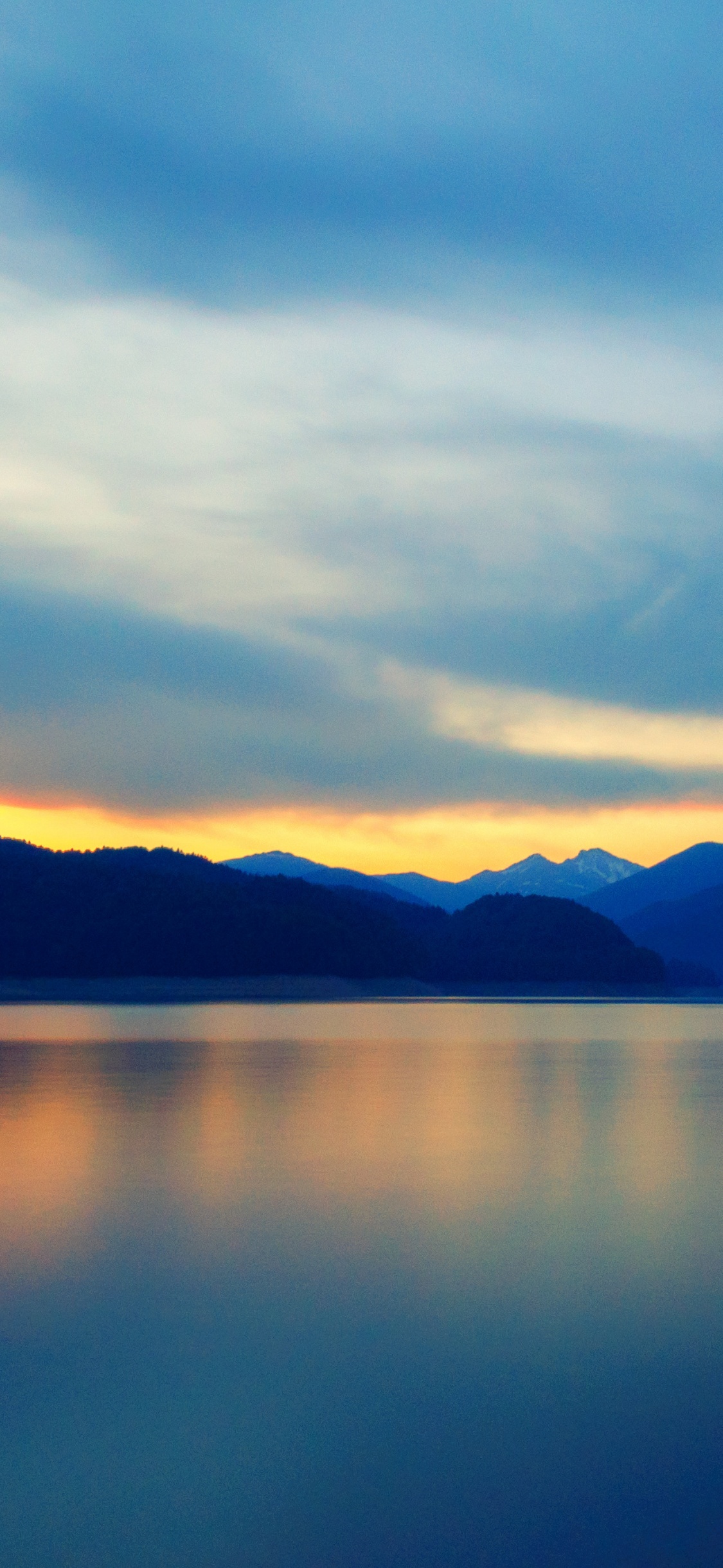 Body of Water Near Mountain During Daytime. Wallpaper in 1125x2436 Resolution