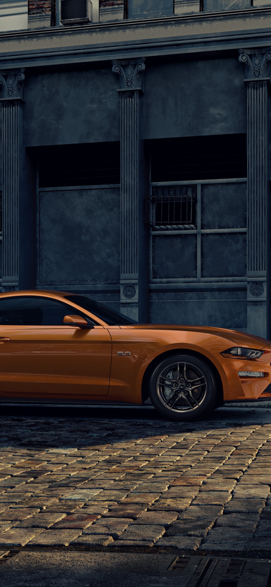 Coche Naranja Aparcado Junto al Edificio. Wallpaper in 1125x2436 Resolution