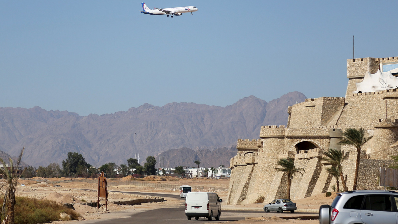 White and Black Airplane Flying Over Brown Concrete Building During Daytime. Wallpaper in 1280x720 Resolution