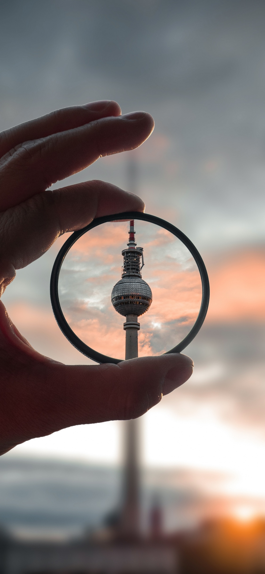 Person Holding Magnifying Glass During Sunset. Wallpaper in 1125x2436 Resolution