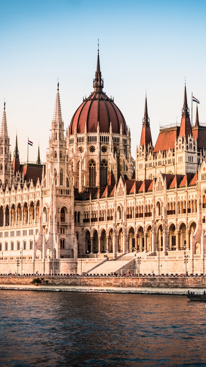 Edificio de Hormigón Marrón y Blanco Cerca Del Cuerpo de Agua Durante el Día. Wallpaper in 720x1280 Resolution