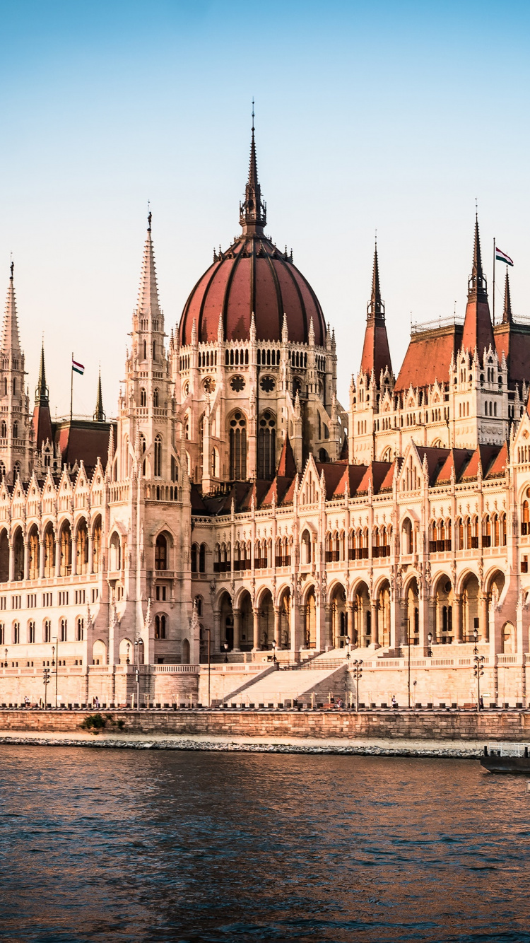 Braunes Und Weißes Betongebäude in Der Nähe Eines Gewässers Tagsüber. Wallpaper in 750x1334 Resolution