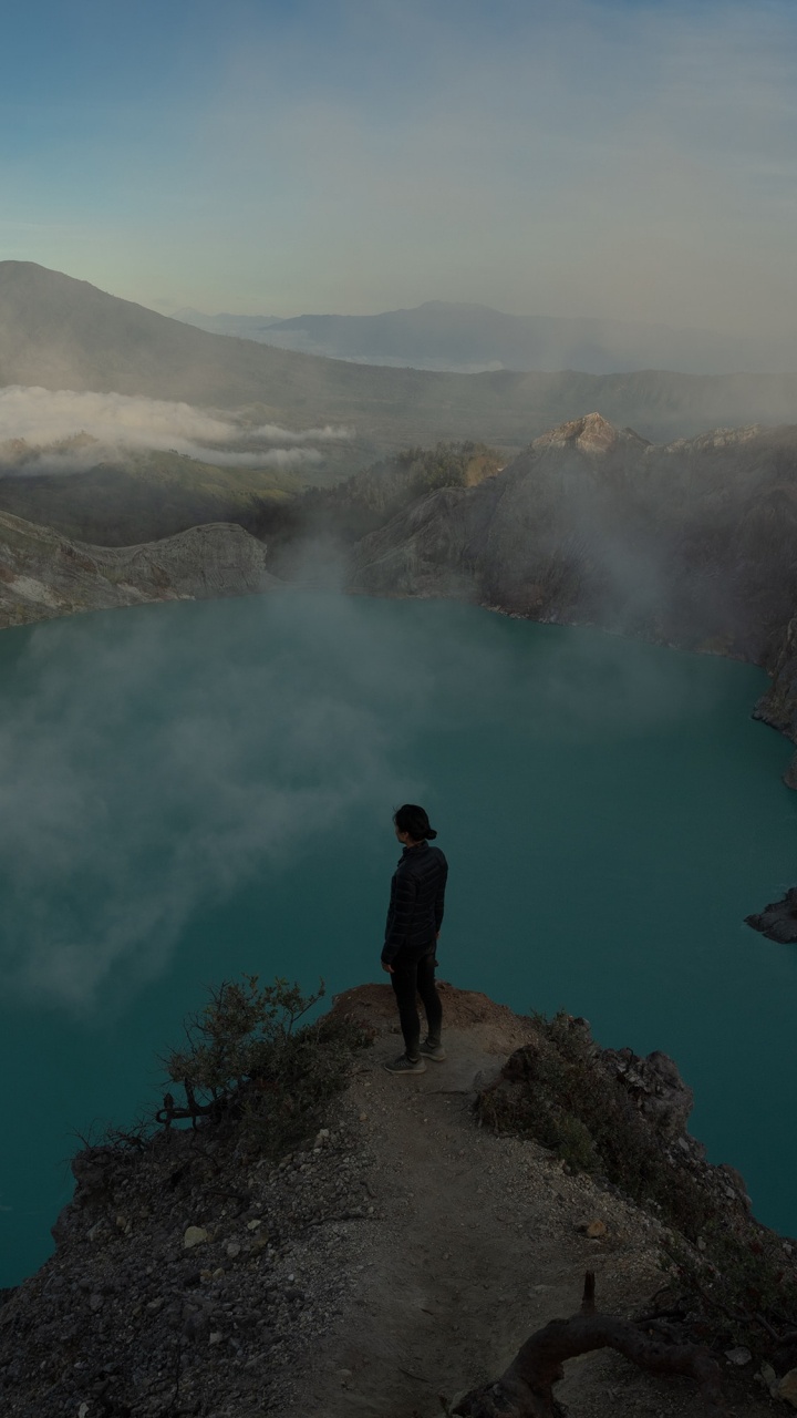 Person Standing on Rock Near Lake During Daytime. Wallpaper in 720x1280 Resolution