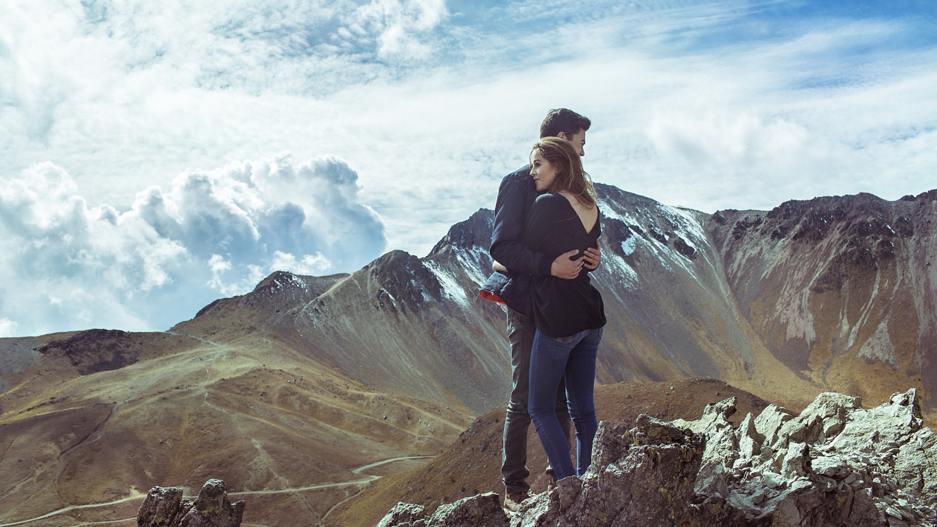 Man in Black Jacket and Black Pants Standing on Rock Formation Under White Clouds During Daytime. Wallpaper in 1366x768 Resolution