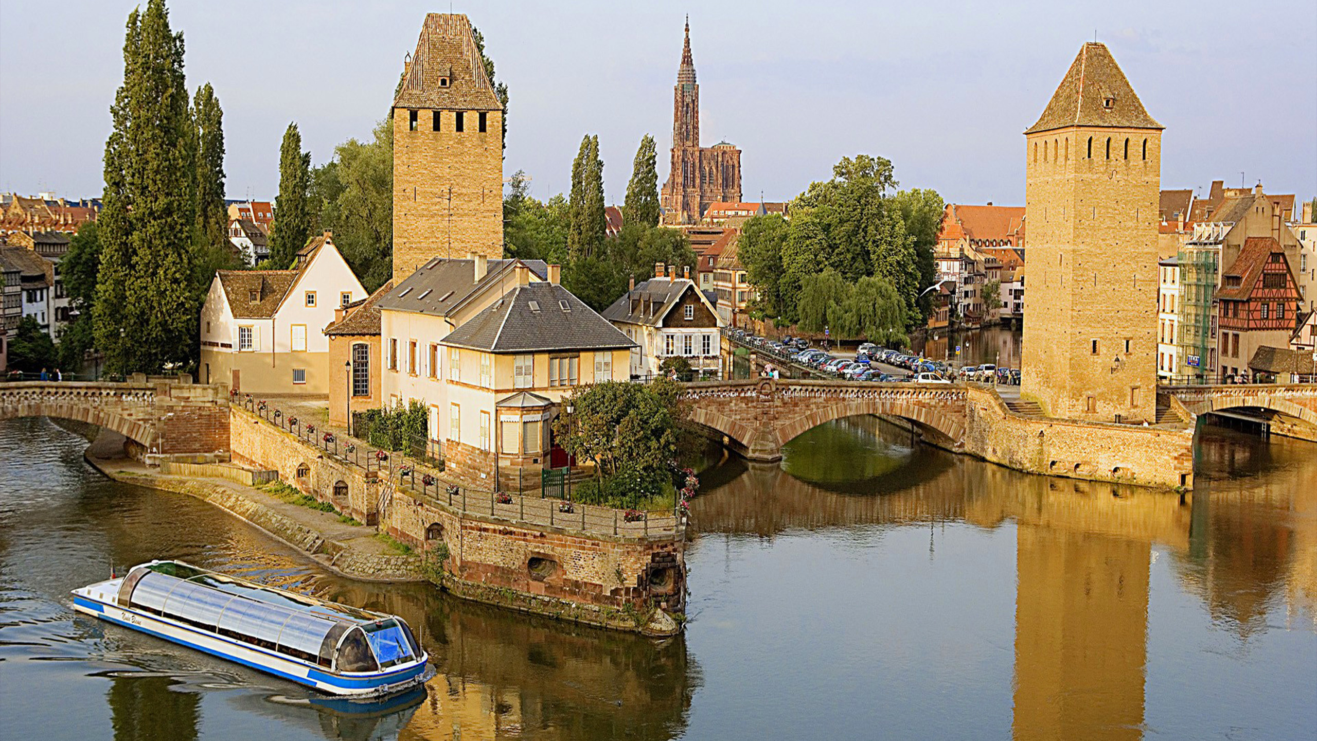 Edificio de Hormigón Marrón Junto al Río Durante el Día. Wallpaper in 2560x1440 Resolution