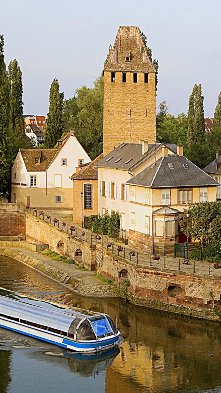 Brown Concrete Building Beside River During Daytime. Wallpaper in 720x1280 Resolution