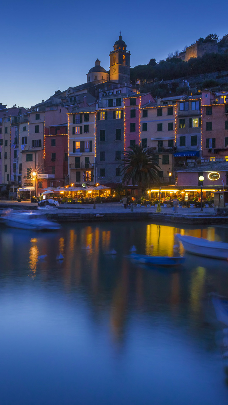 Plan D'eau Entre Les Bâtiments Pendant la Nuit. Wallpaper in 750x1334 Resolution