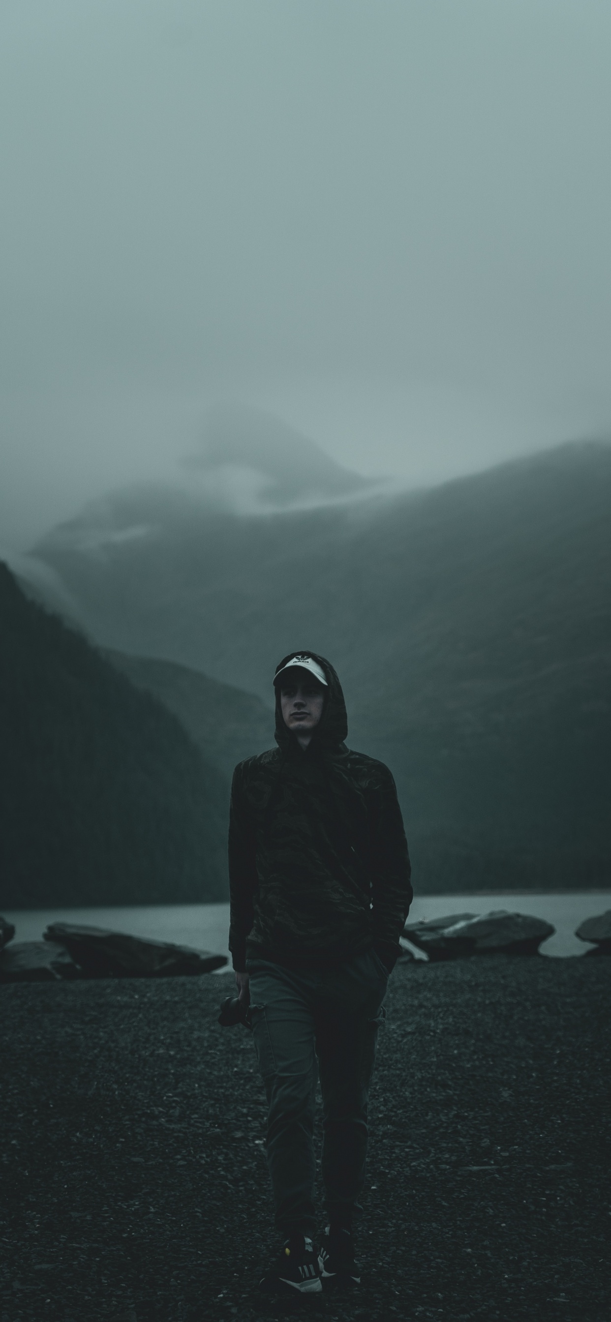 Mann im Schwarzen Hoodie, Der Tagsüber am Strand Steht. Wallpaper in 1242x2688 Resolution