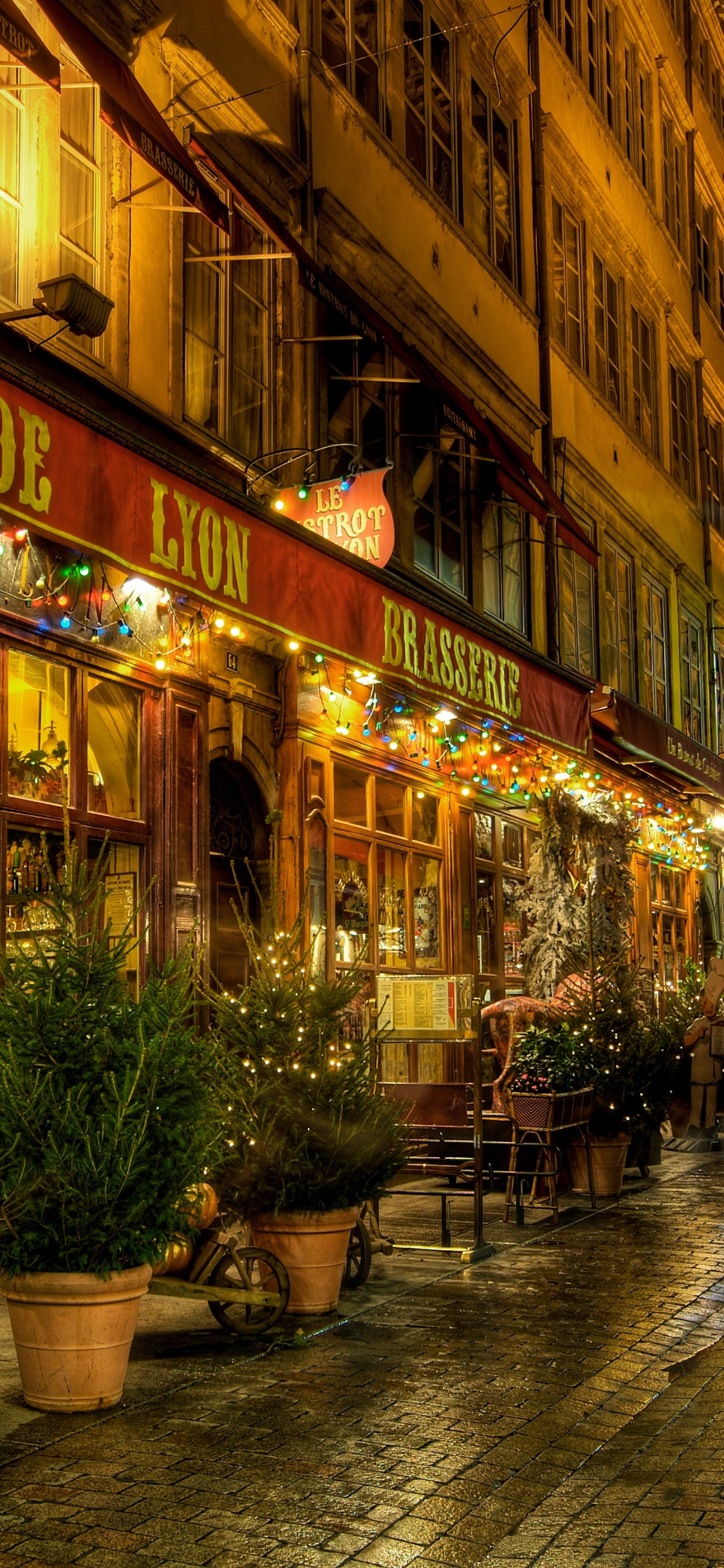 Braunes Betongebäude Mit Nachts Eingeschaltetem Licht. Wallpaper in 1125x2436 Resolution