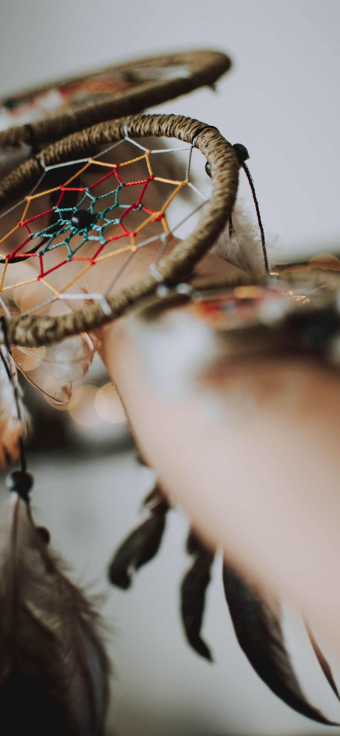 Persona Sosteniendo un Espejo Redondo Marrón y Verde. Wallpaper in 1125x2436 Resolution