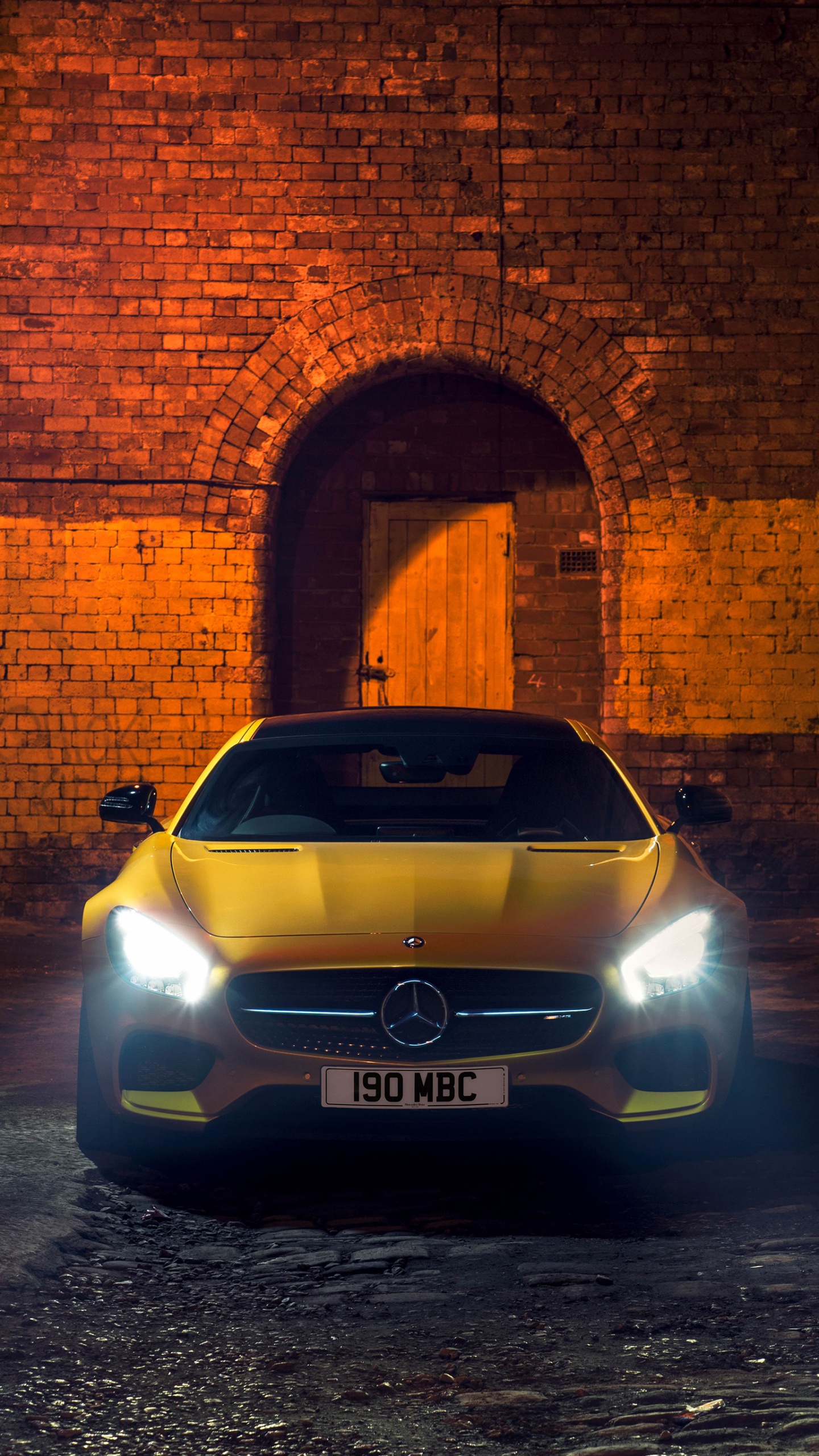 Silver Car Parked Beside Brown Brick Wall. Wallpaper in 1440x2560 Resolution
