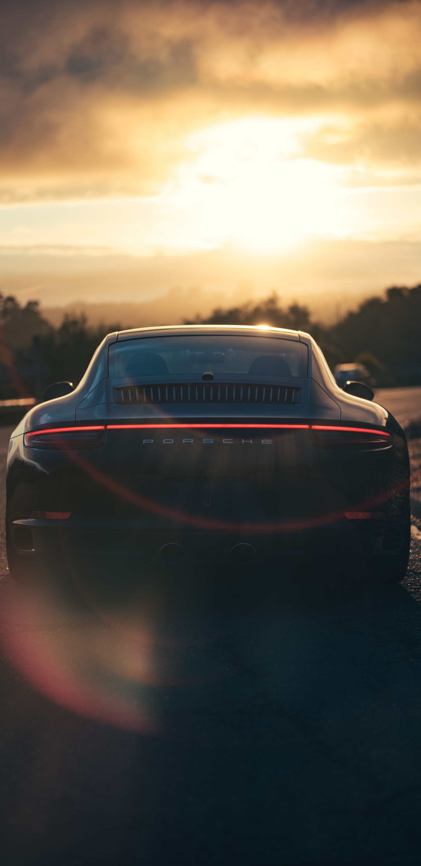 Schwarzes Auto Auf Der Straße Bei Sonnenuntergang. Wallpaper in 1440x2960 Resolution