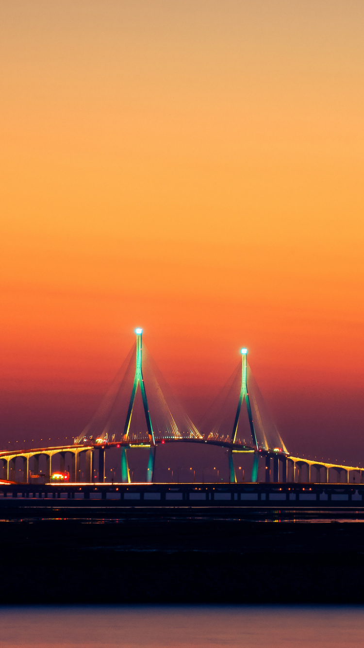 Bridge Over Body of Water During Sunset. Wallpaper in 750x1334 Resolution