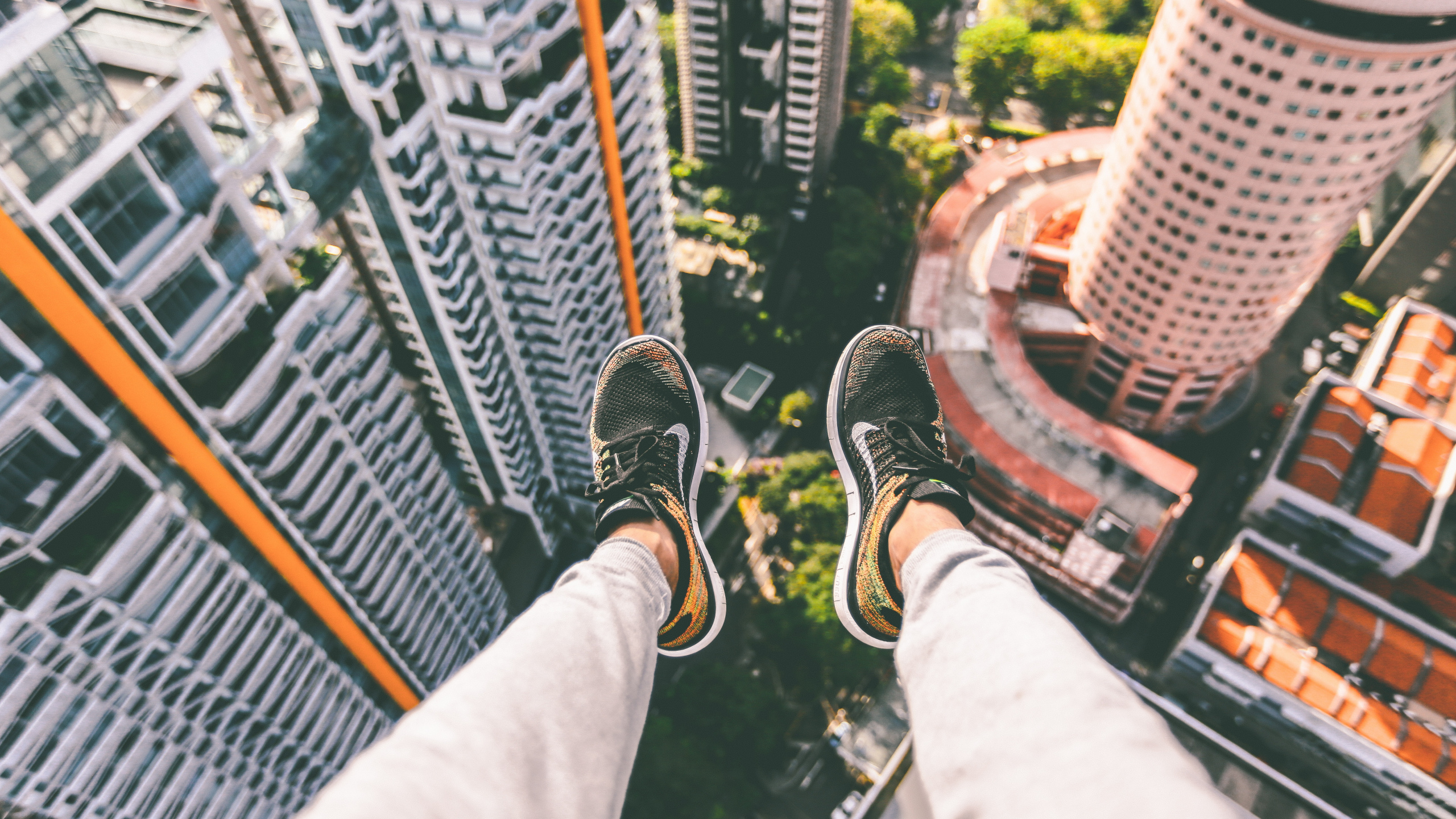 Persona en Zapatillas Blancas y Negras Sentada en la Parte Superior Del Edificio. Wallpaper in 2560x1440 Resolution