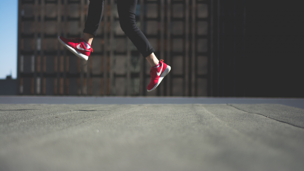 Personne en Pantalon Noir et Baskets Nike Roses Sautant Sur Une Route Goudronnée Noire. Wallpaper in 1280x720 Resolution