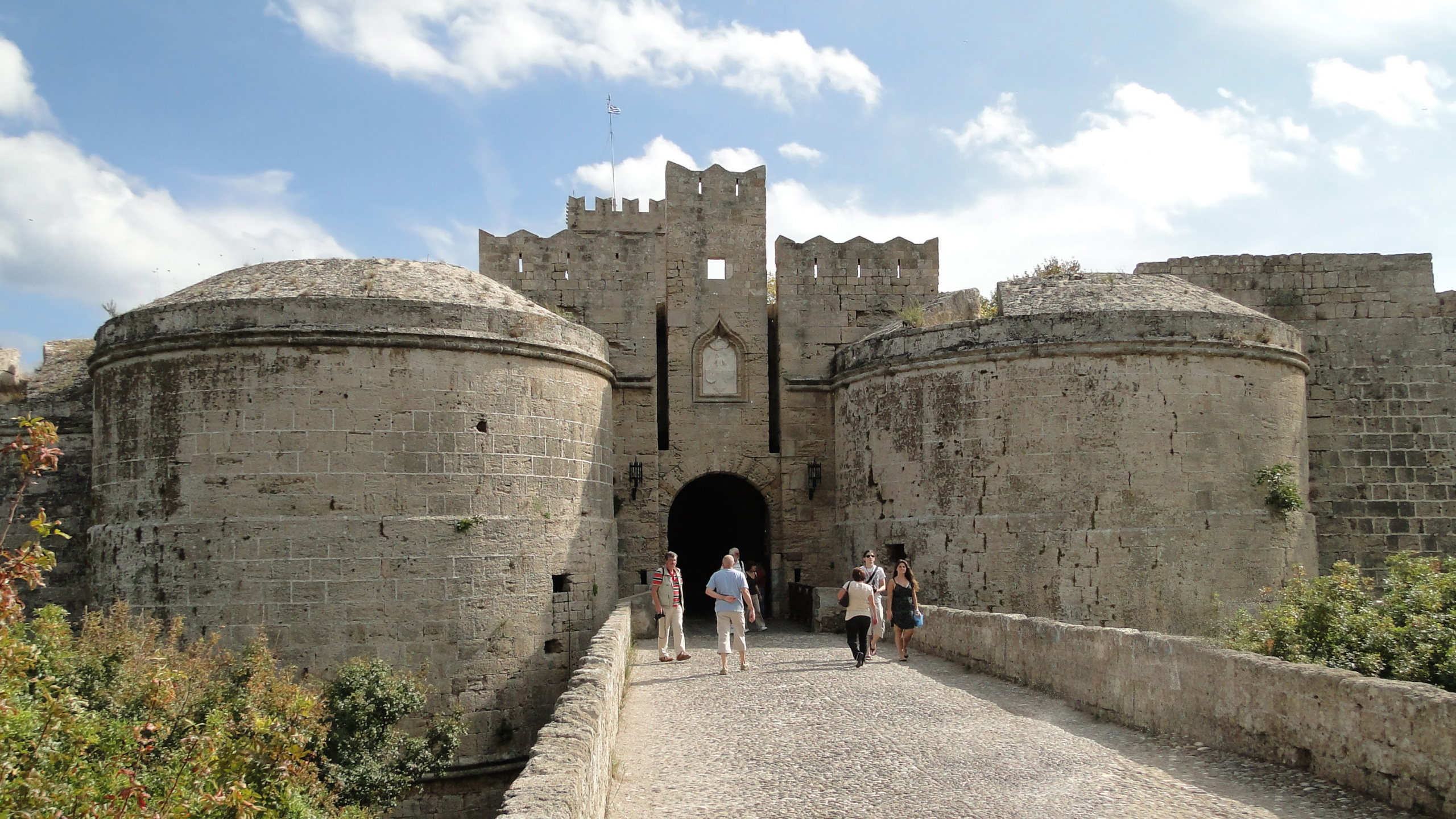 Menschen, Die Tagsüber Auf Einem Grauen Betonweg in Der Nähe Eines Braunen Betongebäudes Gehen. Wallpaper in 2560x1440 Resolution