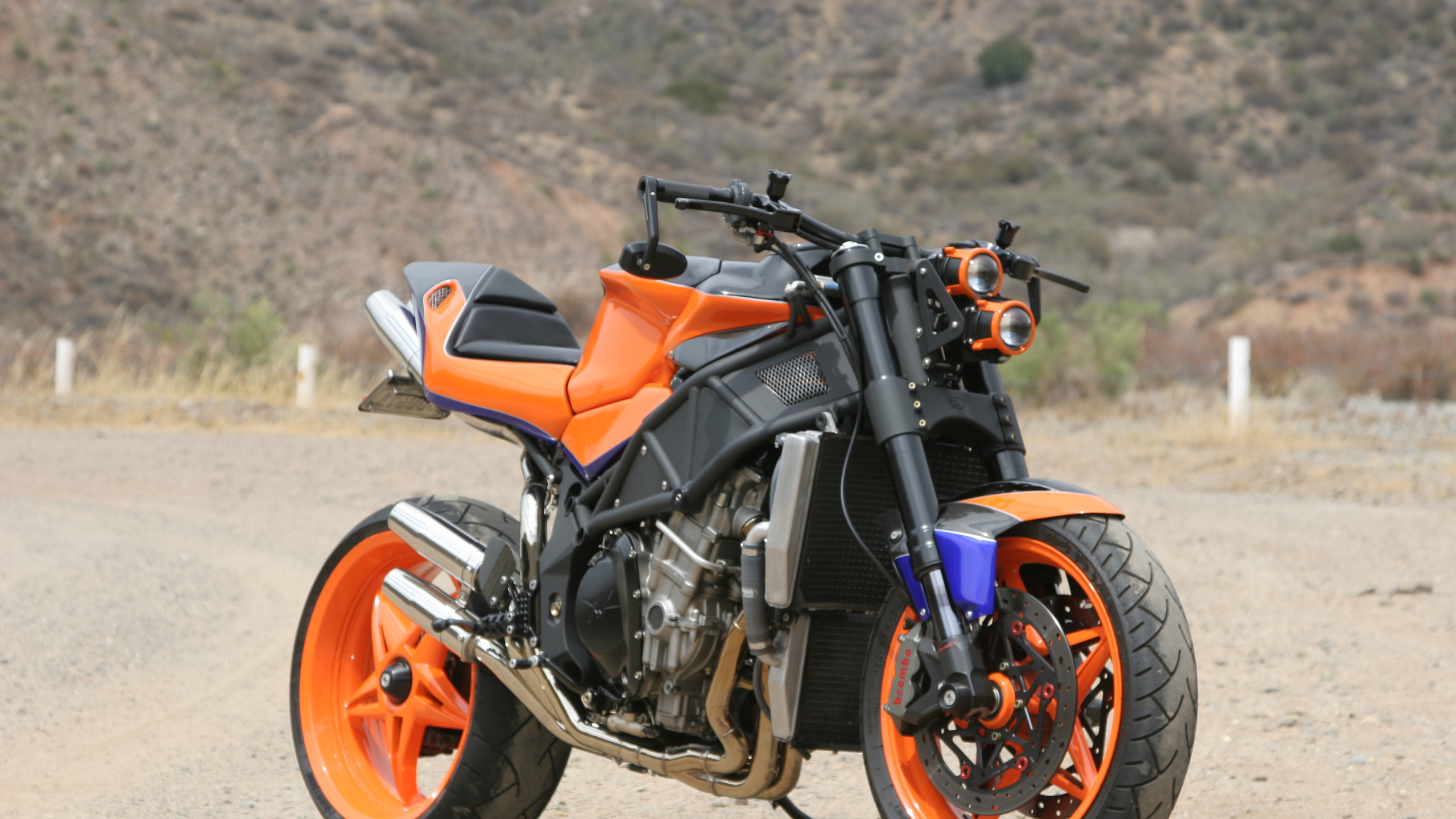 Orangefarbenes Und Schwarzes Motorrad Tagsüber Auf Feldweg. Wallpaper in 2560x1440 Resolution