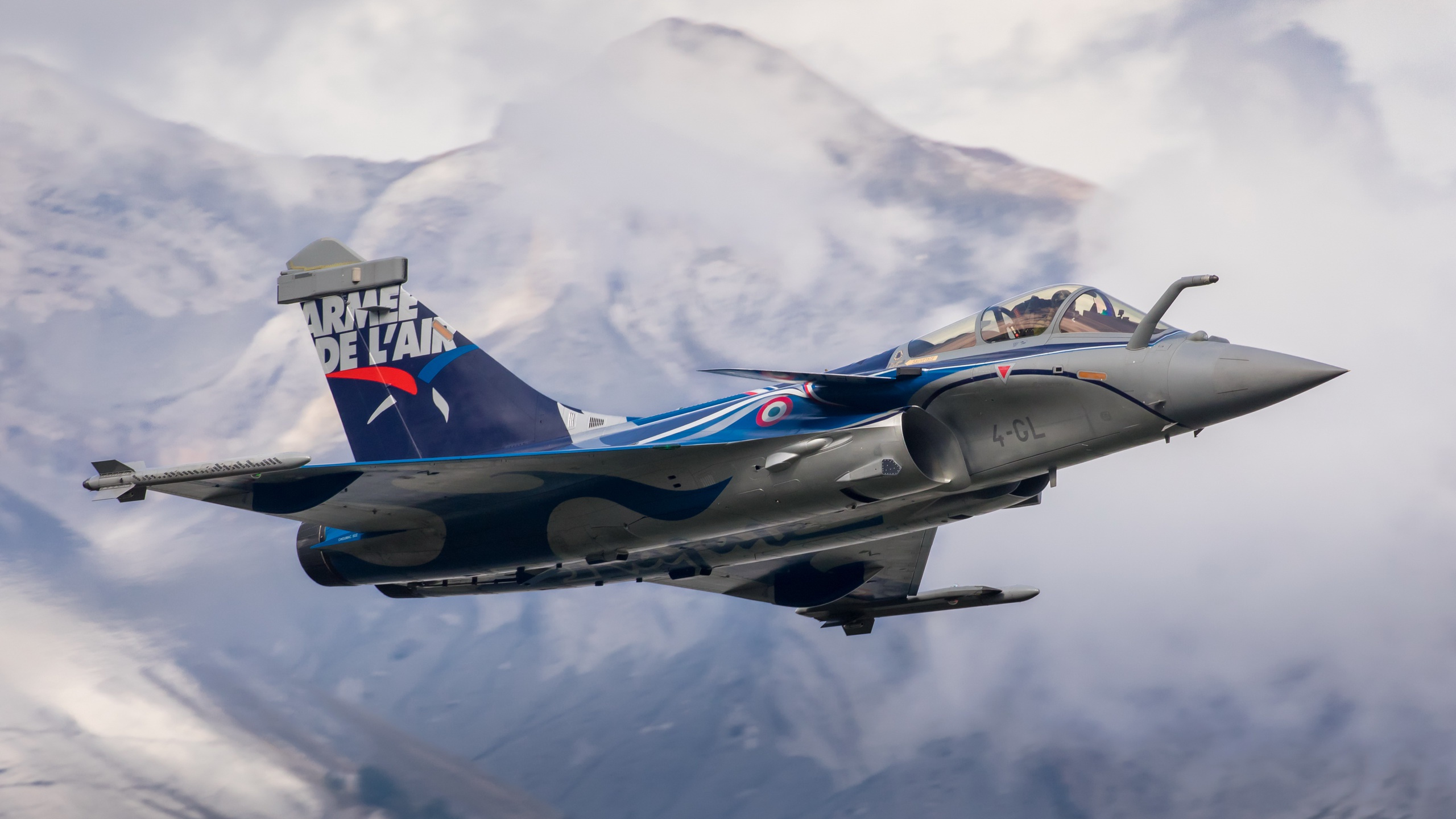 Blau-weißes Düsenflugzeug Fliegt Über Den Berg Flying. Wallpaper in 2560x1440 Resolution