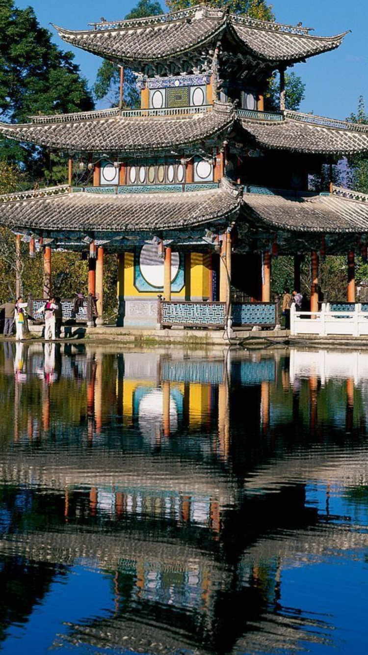 Temple Brun et Blanc Près D'un Plan D'eau Pendant la Journée. Wallpaper in 750x1334 Resolution