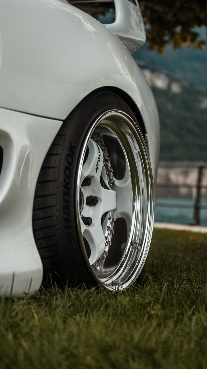 Weißes Auto Auf Grünem Gras Tagsüber. Wallpaper in 720x1280 Resolution