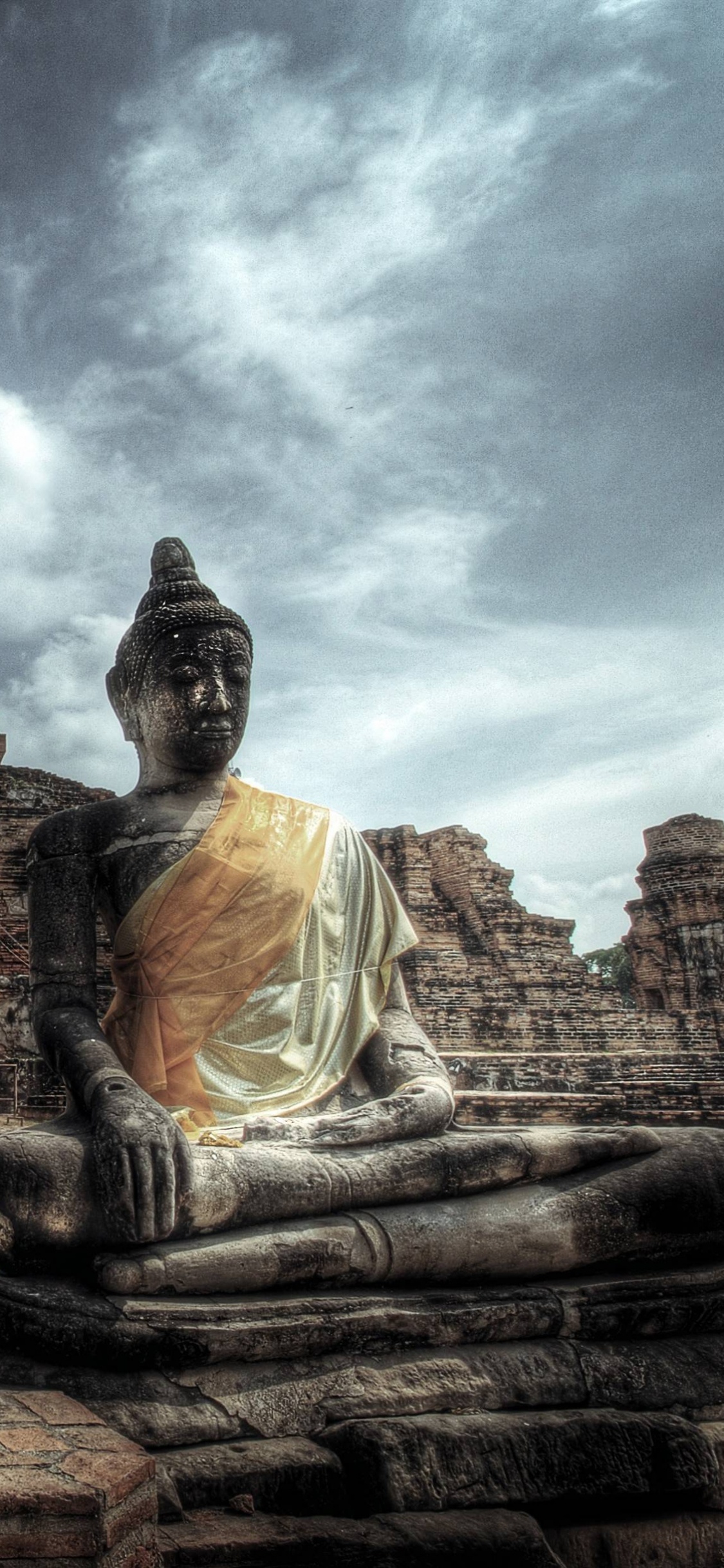 Braune Betonstatue Unter Bewölktem Himmel Tagsüber. Wallpaper in 1125x2436 Resolution