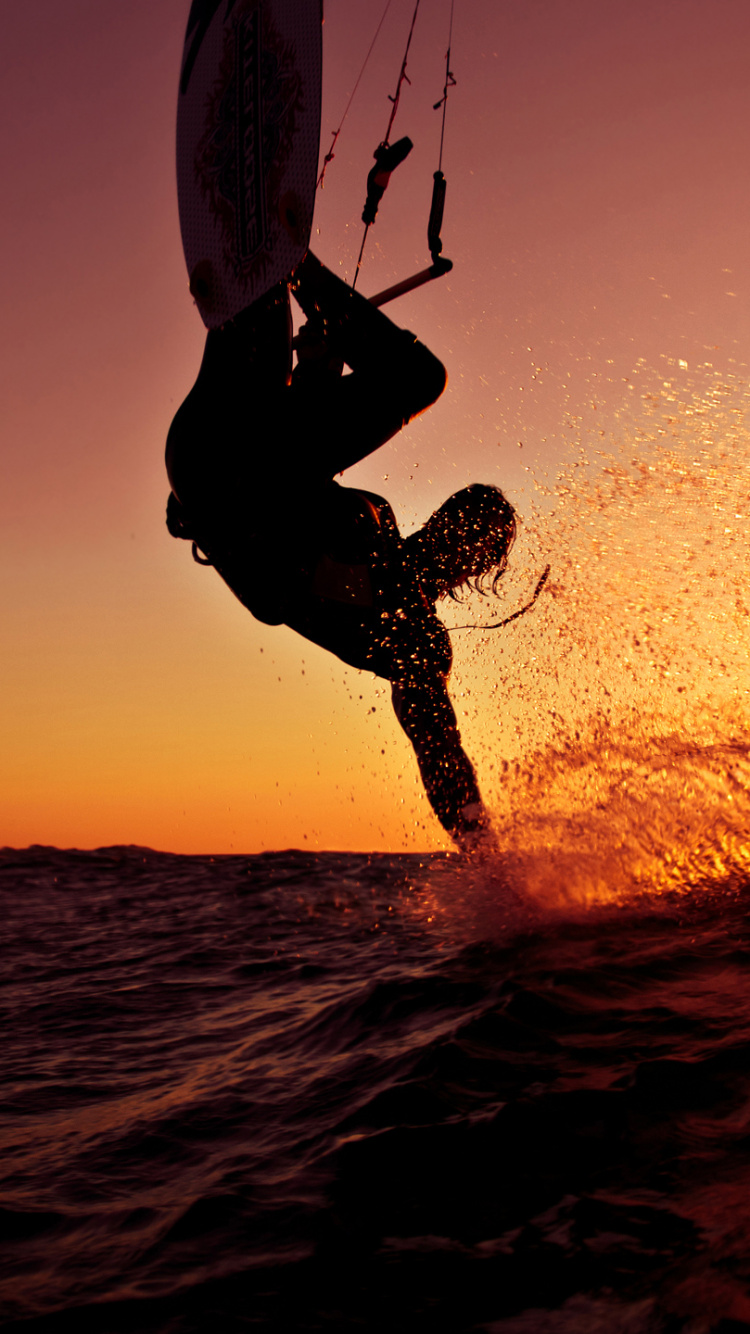 Man in Black Wet Suit Holding White Surfboard on Body of Water During Daytime. Wallpaper in 750x1334 Resolution