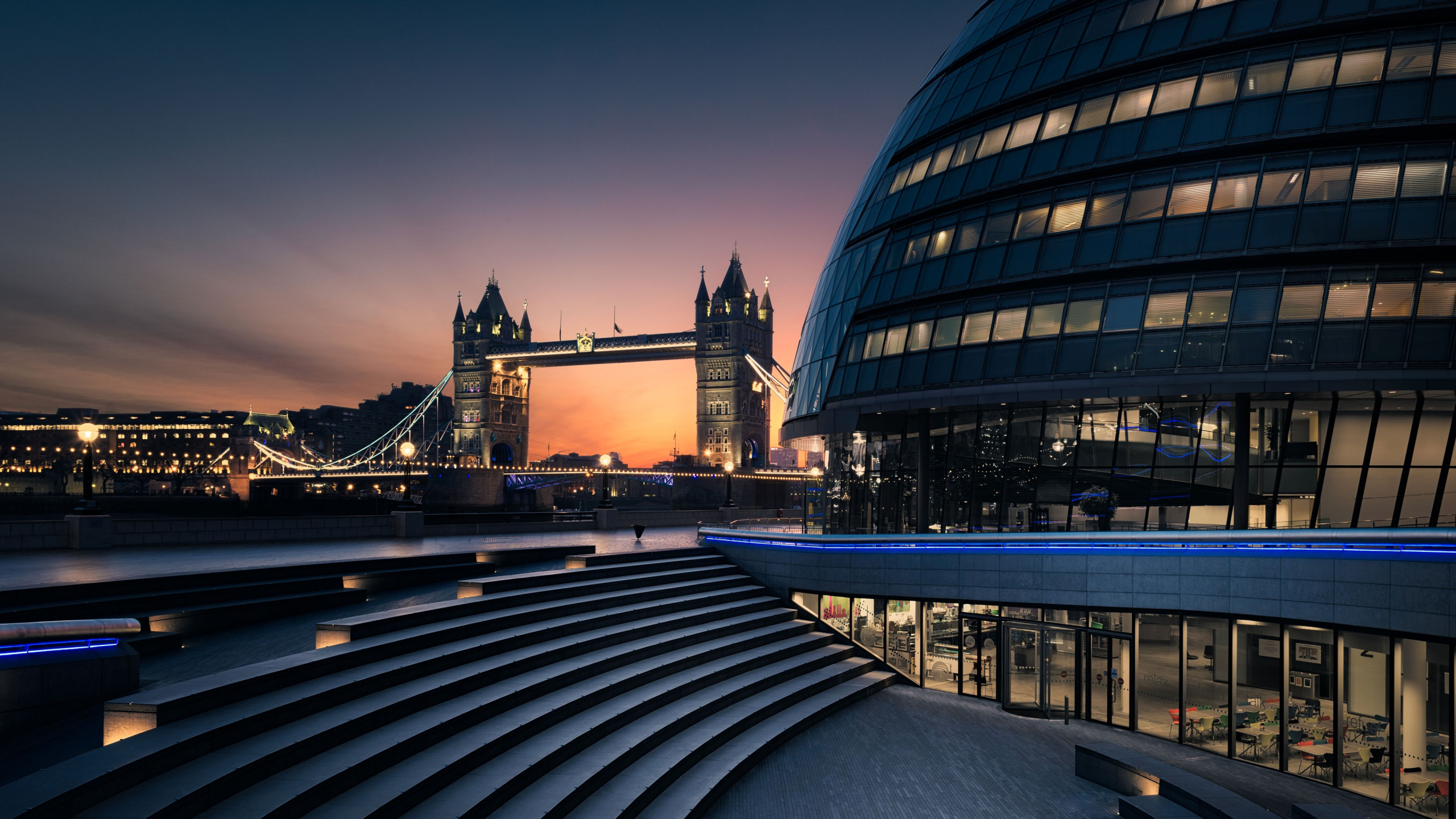 Edificio de Hormigón Negro y Marrón Cerca Del Puente Durante la Noche. Wallpaper in 2560x1440 Resolution