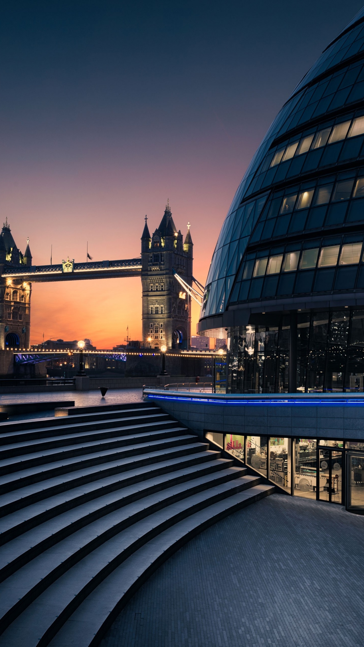 Schwarzes Und Braunes Betongebäude in Der Nähe Der Brücke Während Der Nachtzeit. Wallpaper in 1440x2560 Resolution