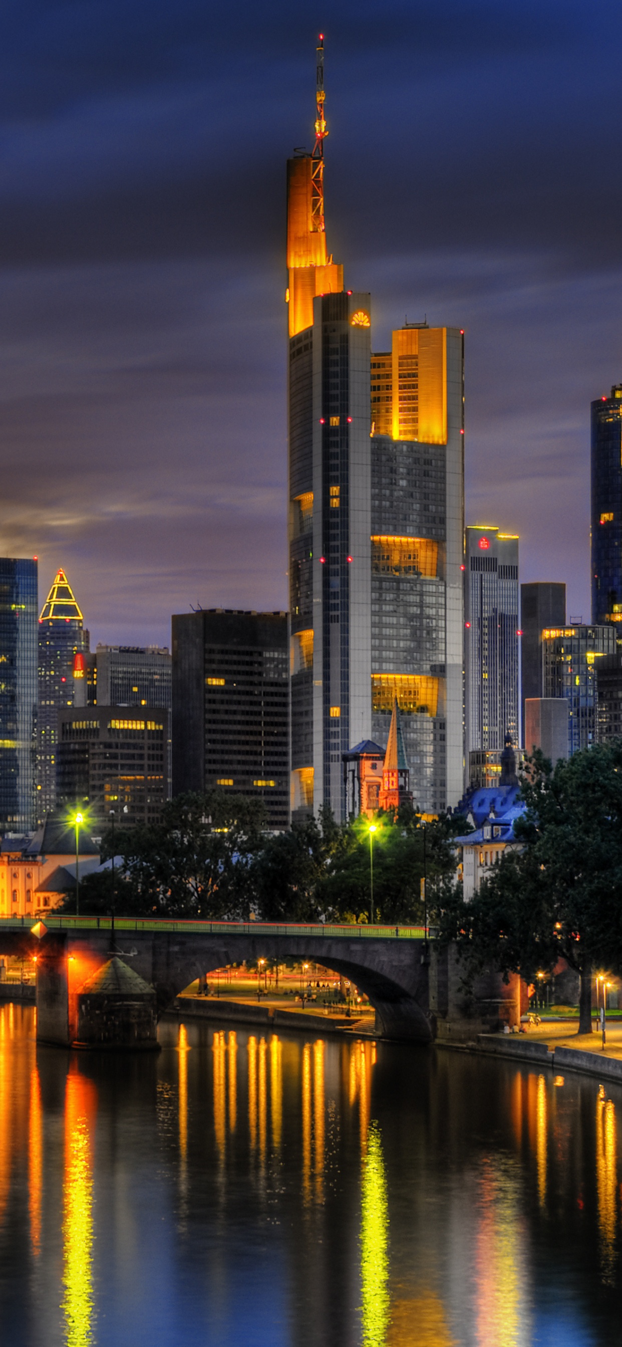 City Skyline Across Body of Water During Night Time. Wallpaper in 1242x2688 Resolution