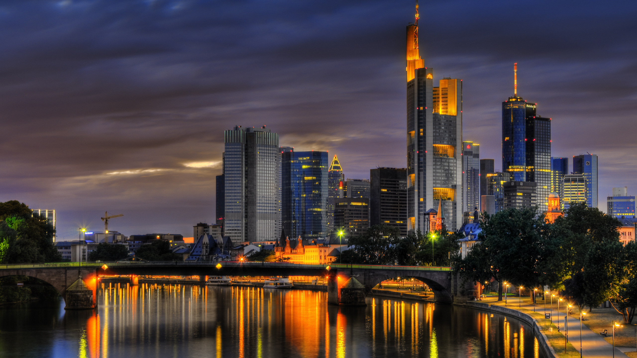 Skyline Der Stadt Über Gewässer Während Der Nacht. Wallpaper in 2560x1440 Resolution