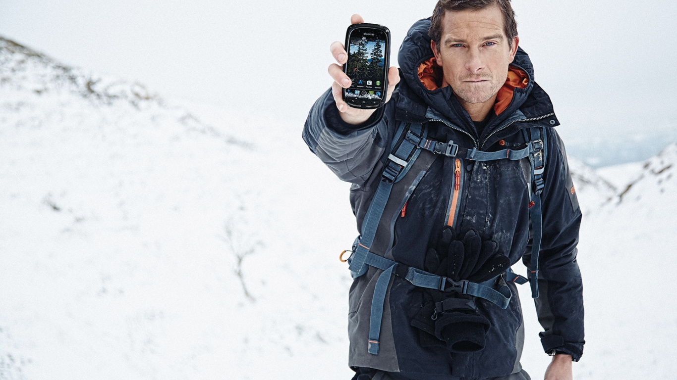 Man in Black and Red Zip up Jacket Holding Black Smartphone. Wallpaper in 1366x768 Resolution