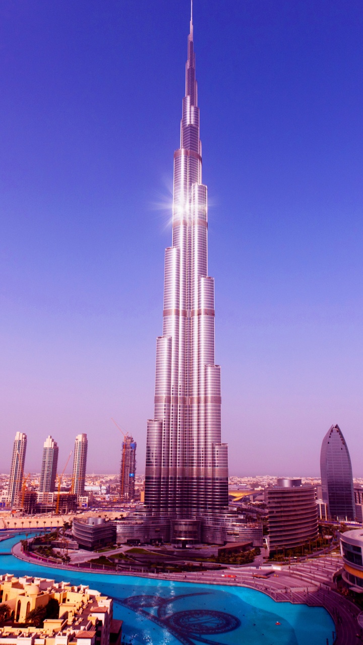 White and Blue Boat on Sea Shore Near City Buildings During Daytime. Wallpaper in 720x1280 Resolution