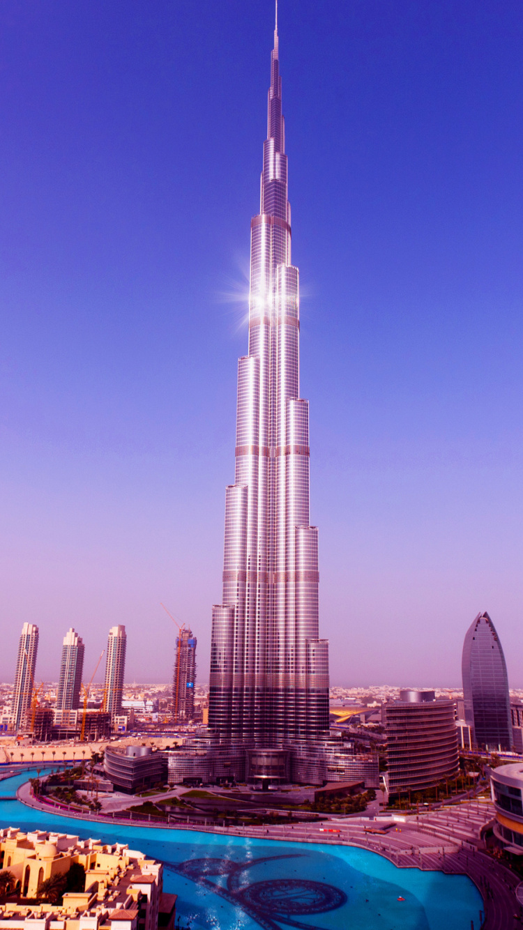 White and Blue Boat on Sea Shore Near City Buildings During Daytime. Wallpaper in 750x1334 Resolution