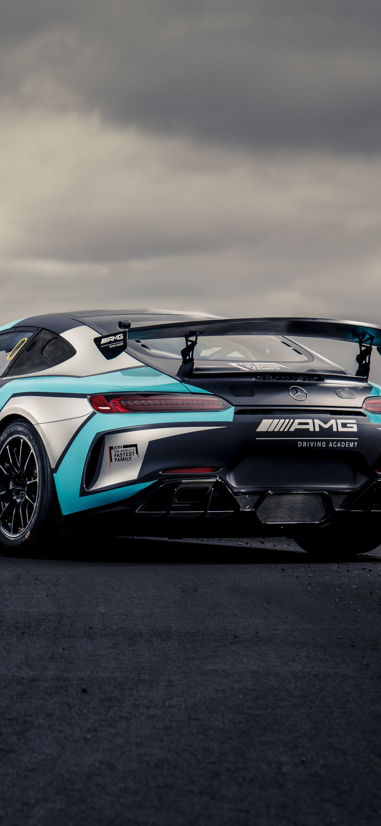 Blue and White Bmw m 3 Coupe on Black Asphalt Road Under Gray Cloudy Sky. Wallpaper in 1242x2688 Resolution