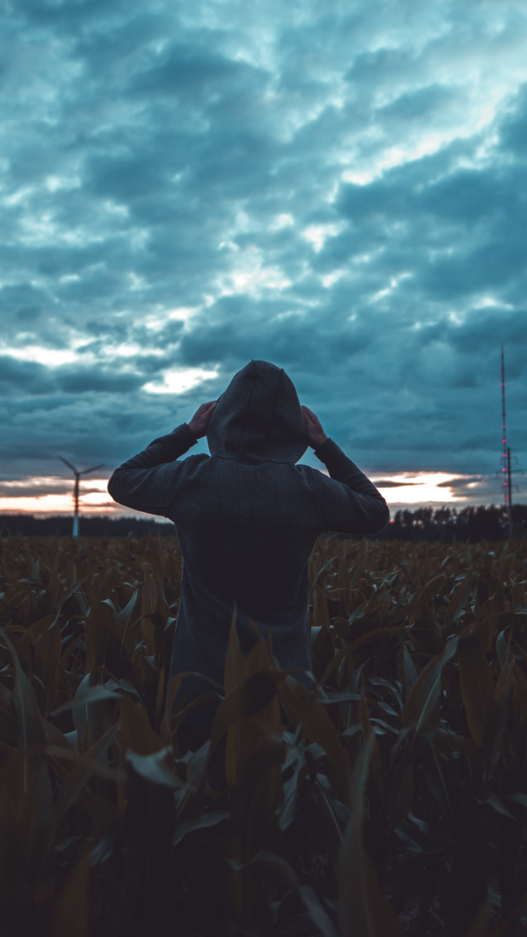 Woman in Black Shirt Standing on Brown Field Under Gray Clouds During Daytime. Wallpaper in 750x1334 Resolution