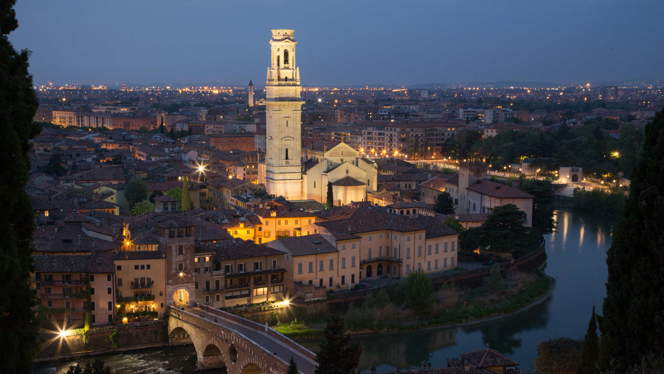 Bâtiment en Béton Blanc et Marron Près D'un Plan D'eau Pendant la Nuit. Wallpaper in 2560x1440 Resolution