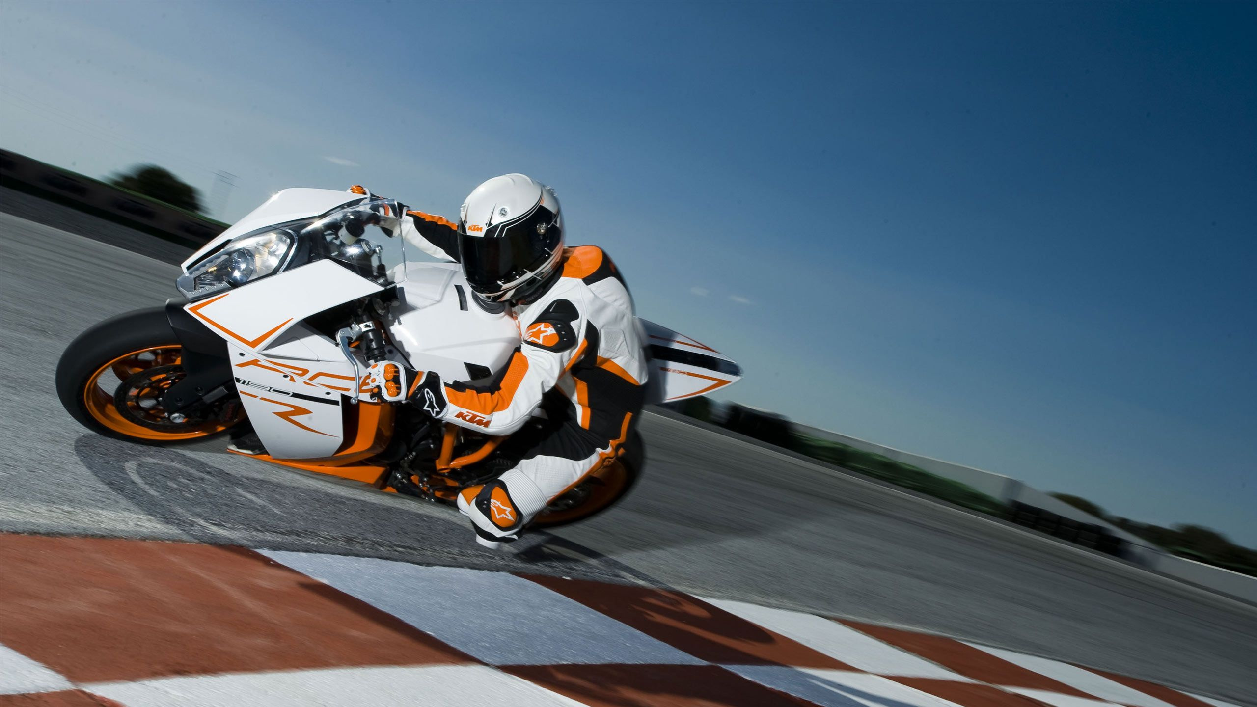 Vélo de Sport Blanc et Orange Sur Piste. Wallpaper in 2560x1440 Resolution