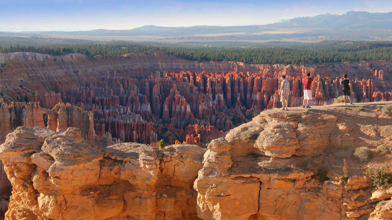 People Standing on Brown Rock Formation During Daytime. Wallpaper in 1366x768 Resolution