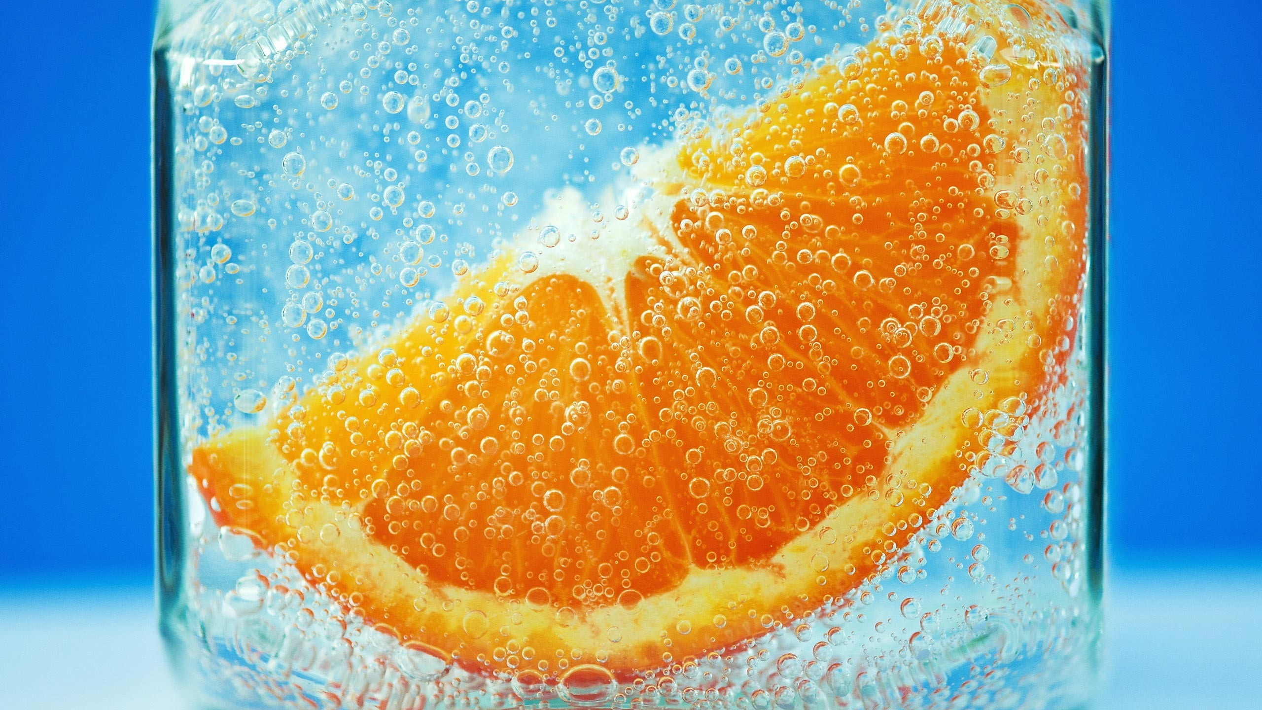 Orangenfrucht Auf Blauem Wasser. Wallpaper in 2560x1440 Resolution